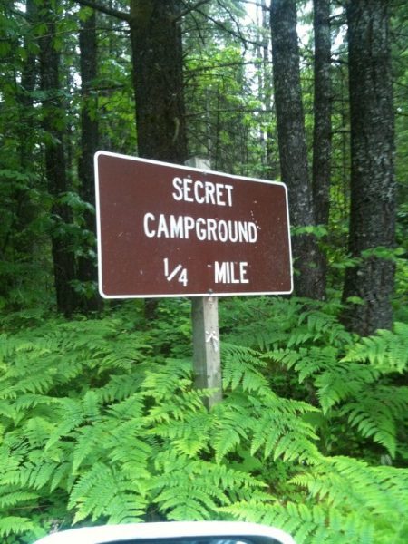 secret camping ground road sign 